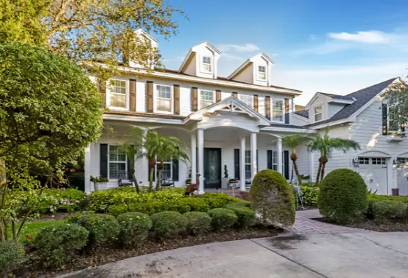 Large white house with multiple peaks and a new roofing system provided by Done Rite Roofing.